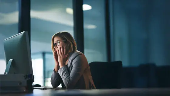 Woman in front of computer with anxiety about fraud