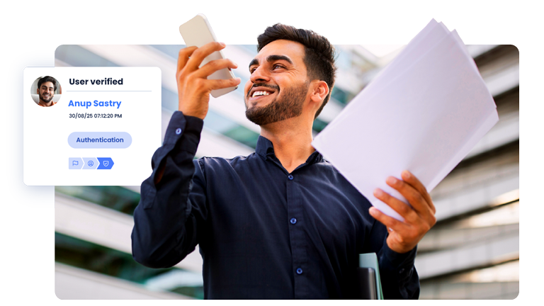 Man holding documents in one hand and a mobile device in the other