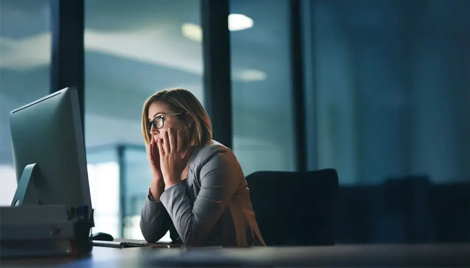 Woman in front of computer with anxiety about fraud