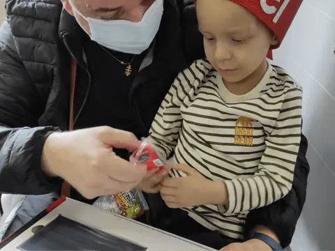 Un voluntario de Facephi con Daniel, un niño con una grave enfermedad