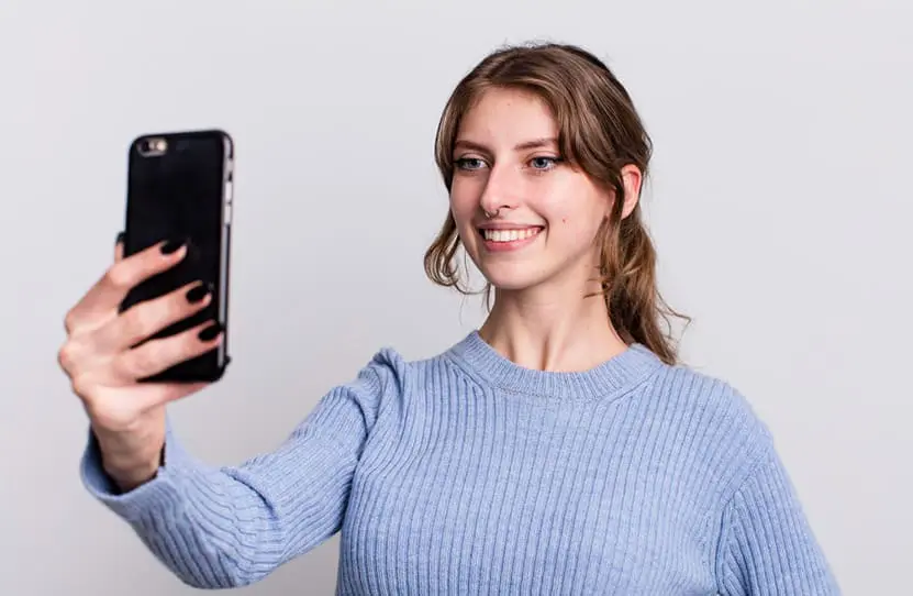 Mujer joven realizando reconocimiento facial con un dispositivo móvil
